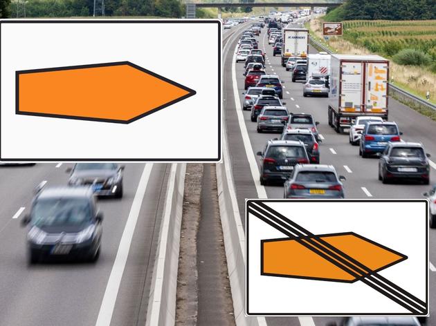 orangefarbener pfeil auf der autobahn – schild ist eine hilfe für autofahrer