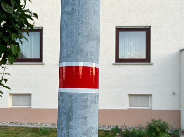 rot-weißer aufkleber auf straßenlaternen: das bedeutet der sticker